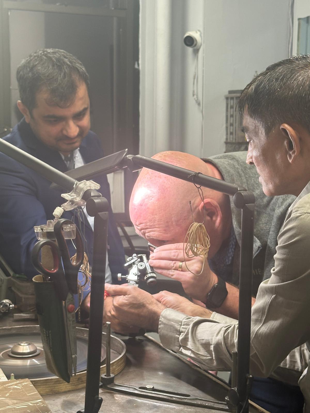 guest checking a diamond getting polished